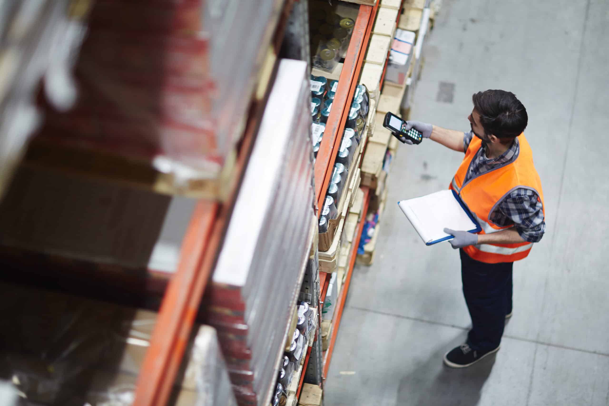 Checking barcodes Worker with scanner making review of goods in warehouse.