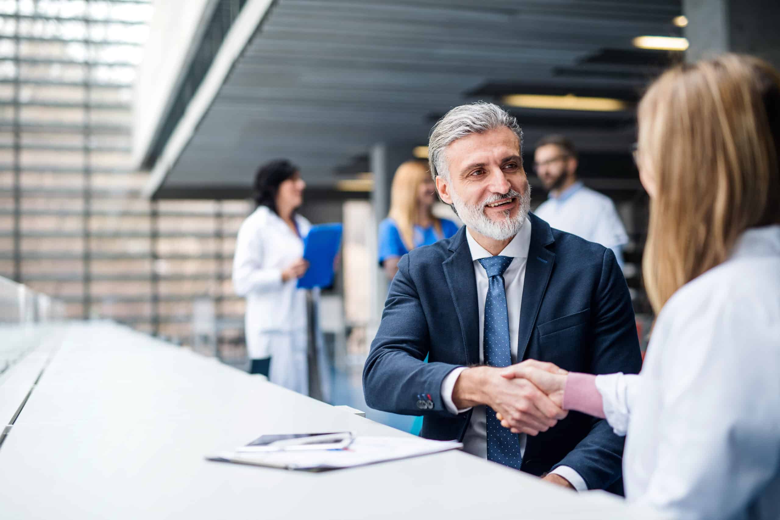 Doctors talking to pharmaceutical sales representative, shaking hands. Group of doctors talking to pharmaceutical sales representative, shaking hands.
