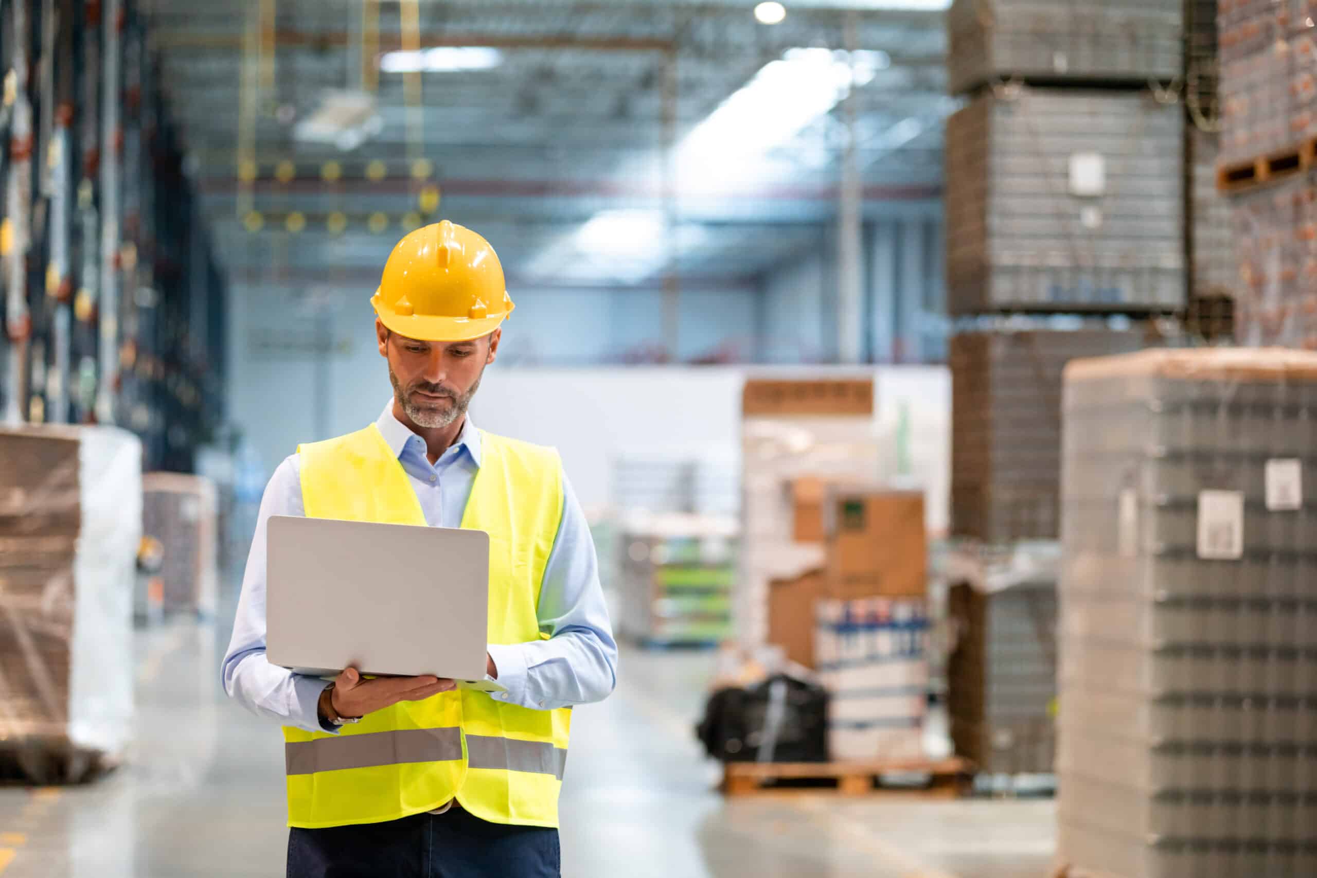 Warehouse manager with laptop entering inventory data to database Warehouse manager with laptop entering inventory data to database.