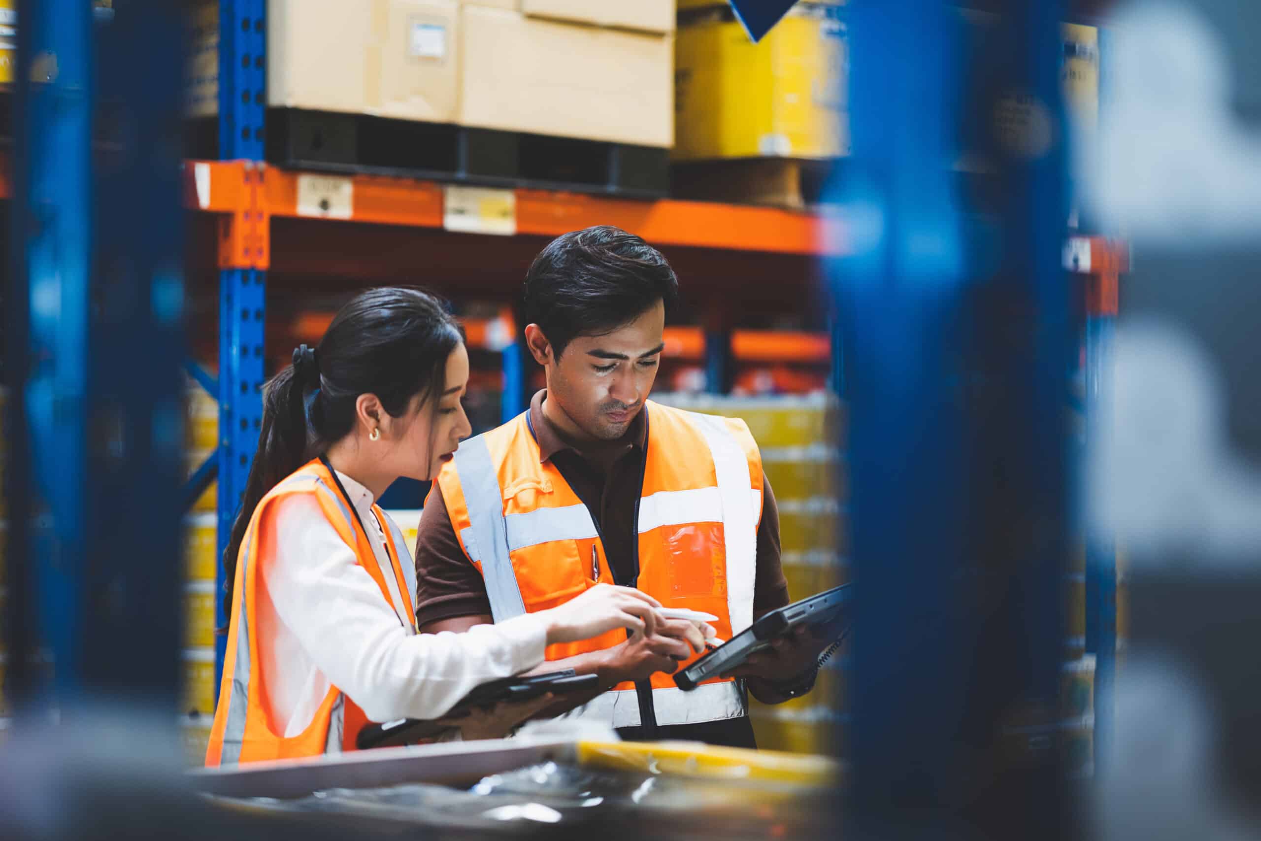 Warehouse worker and manager checks stock and inventory with usi Warehouse worker and manager checks stock and inventory with using digital tablet computer in the retail warehouse full of shelves with goods. Working in logistics, Distribution center.