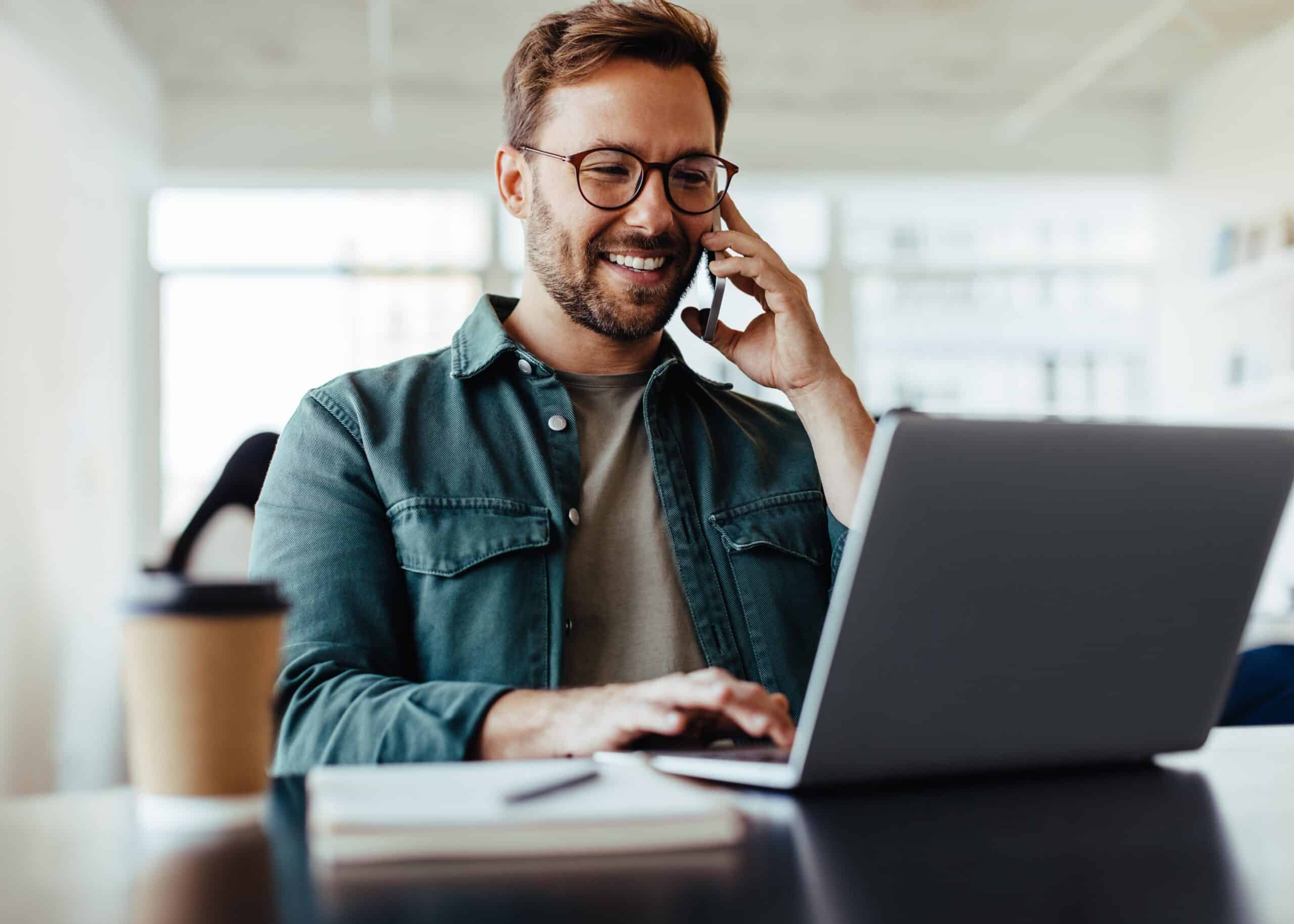 Software designer speaking to his client on the phone in an office Software designer speaking to his client on the phone in an office.
