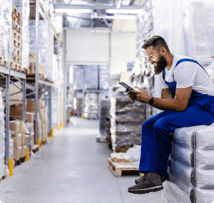 CX1 Product Content Man hunched over, sitting on top of overstock inventory looking into his mobile phone.