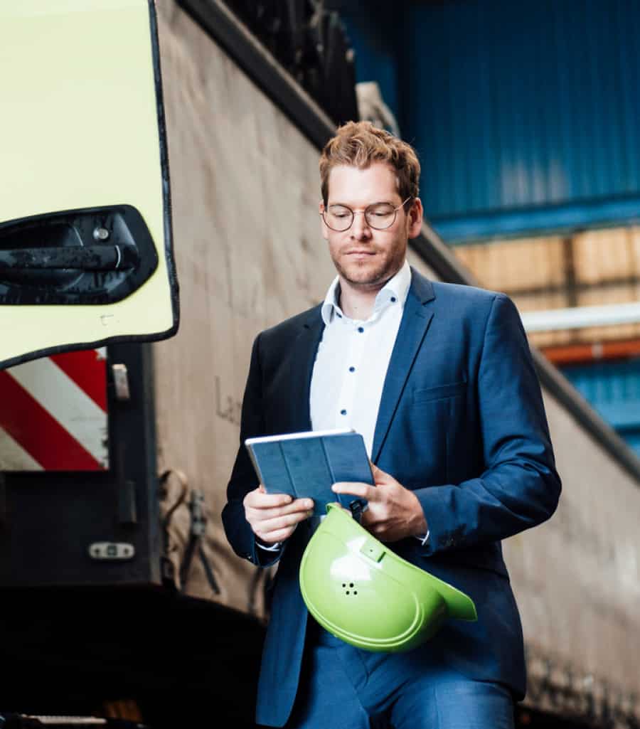 wholesale-hero Man with glasses, he is wearing a suit and in his hands he has a tablet and a safety helmet.