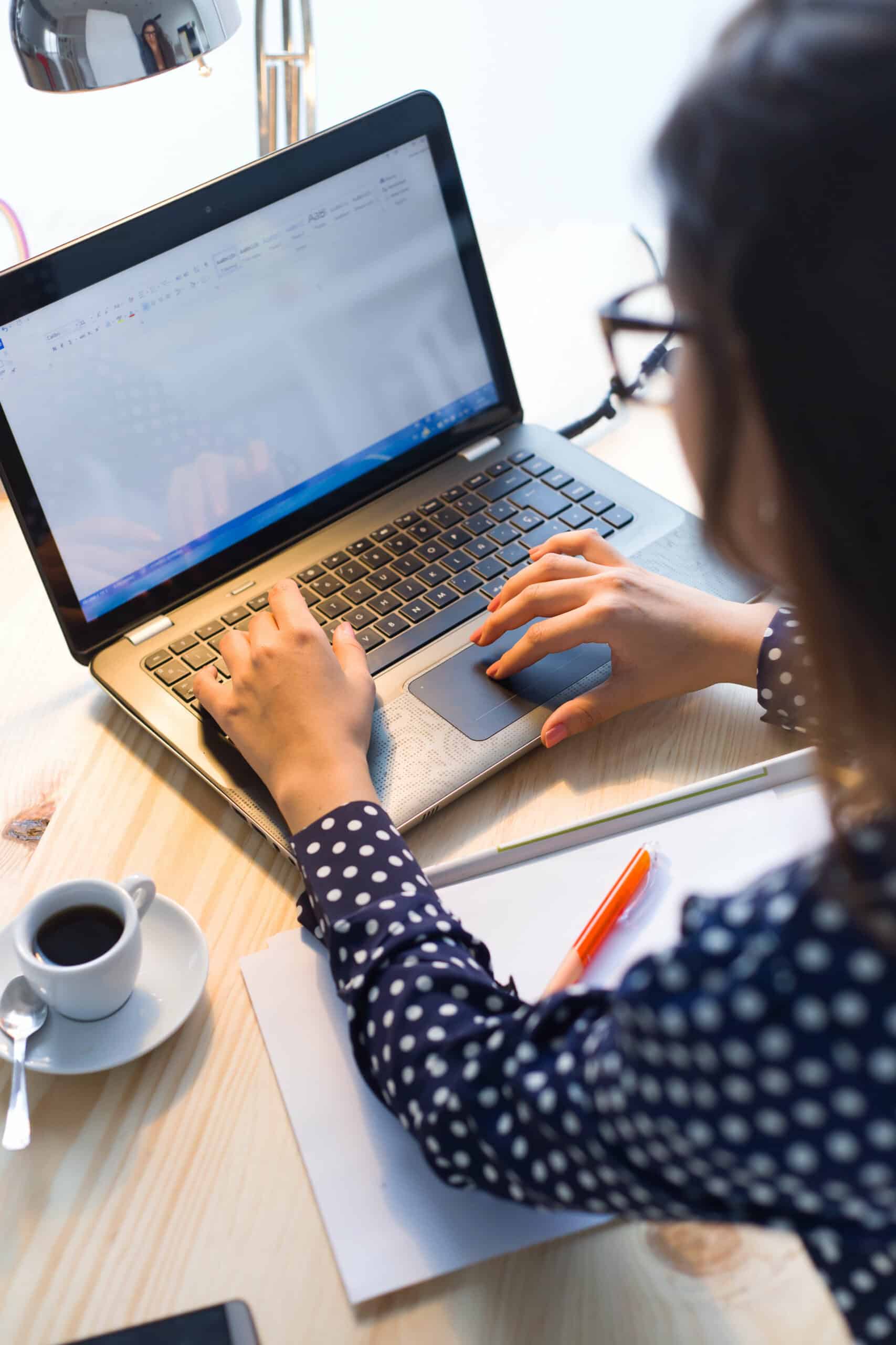 AdobeStock_92614965 (1) Woman typing a document on a laptop.