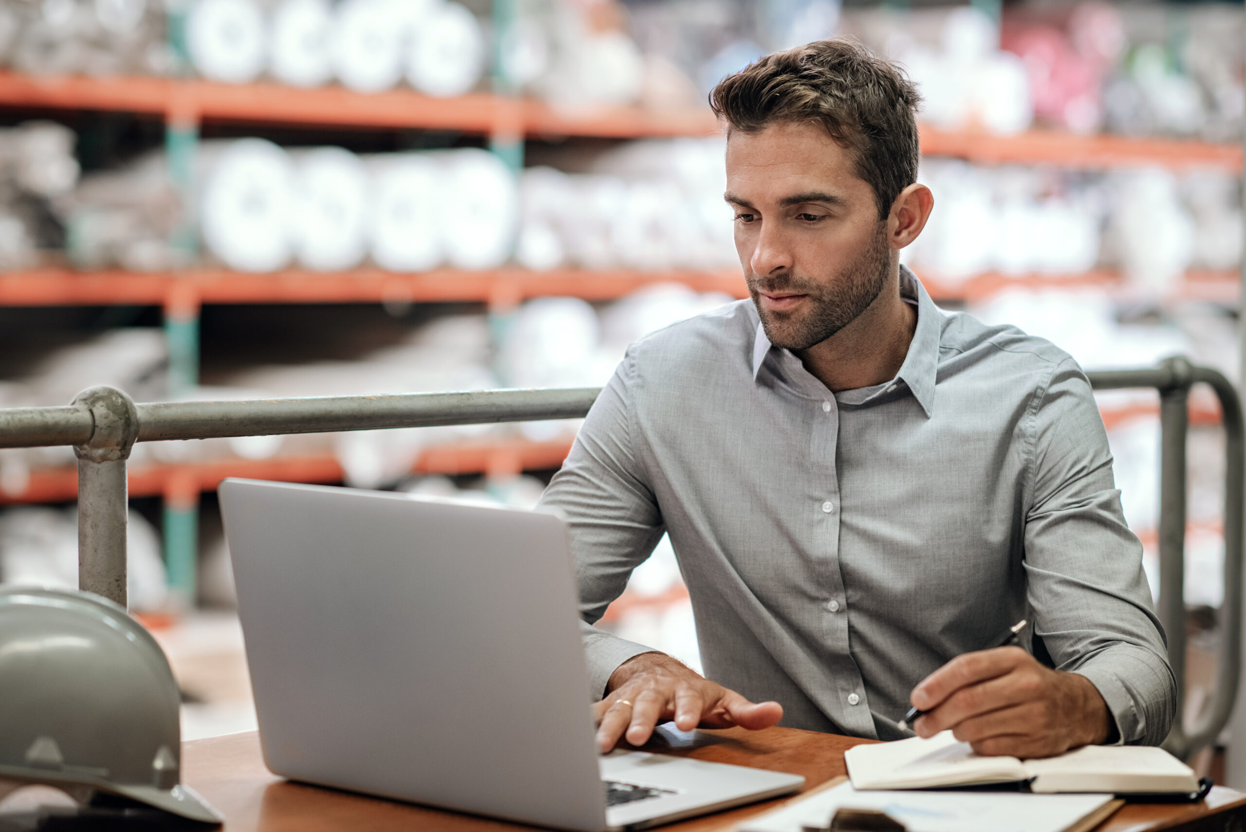 Warehouse manager taking notes and checking orders with a laptop hvac employee