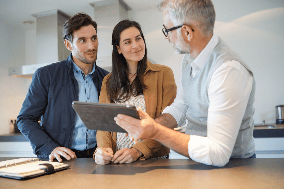 Showroom manager showing tablet to couple