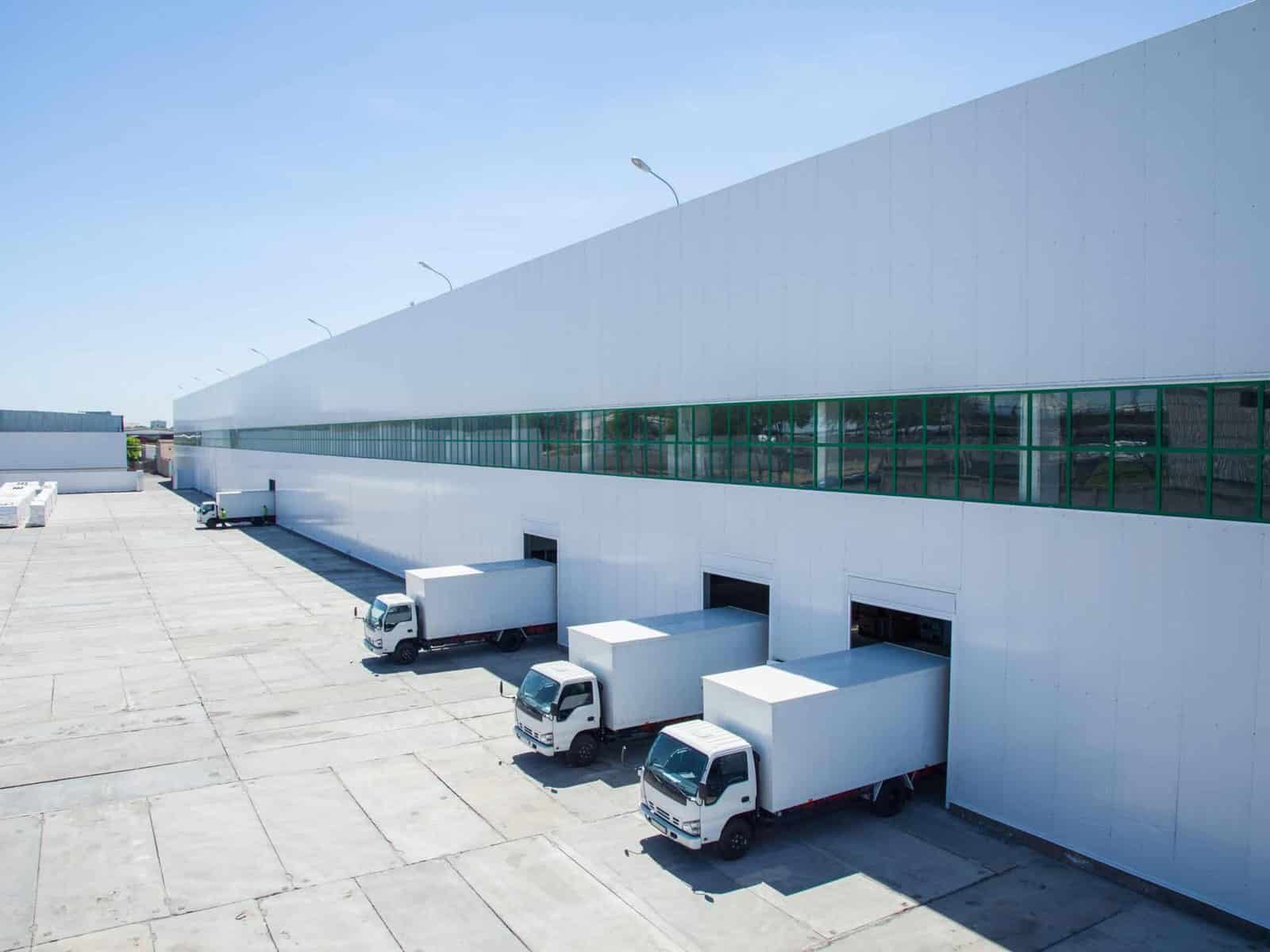 Row of delivery trucks at the loading bays of a wholesale distribution warehouse